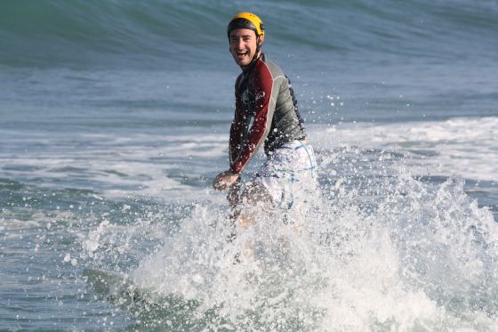 Boris heureux de surfer avec un casque pour protéger sa tête d'un traumatisme crânien
