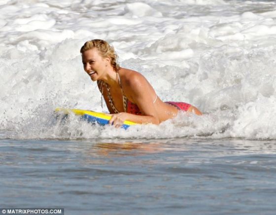 Charlize Theron surfe sur un bodyboard à la plage. Copyright Matrixphotos